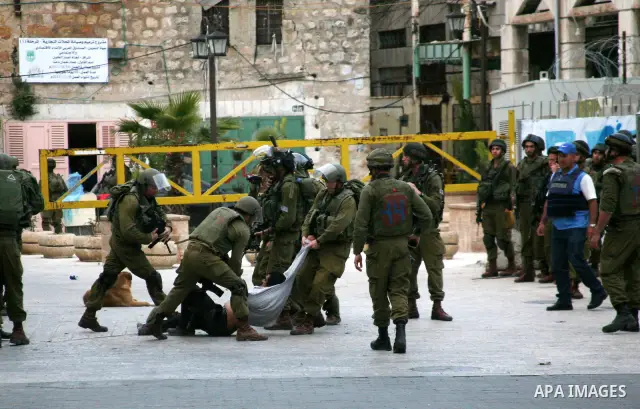 Israeli policemen and soldiers detain Palestinian protesters and foreign activists on April 01, 2012, after they took refuge in an abandoned house and fly a Palestinian flag on the rooftop of the building near the Beit R...