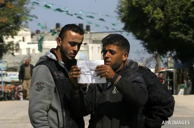 Palestinians read sheets which were thrown by Israeli aeroplane warning the Palestinians from reaching the no-go zone on the border with Israel,in the Rafah on the southern Gaza Strip on April 2,2012. Photo by Eyad Al Ba...