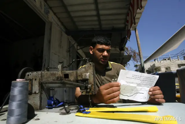Palestinians read sheets which were thrown by Israeli aeroplane warning the Palestinians from reaching the no-go zone on the border with Israel,in the Rafah on the southern Gaza Strip on April 2,2012. Photo by Eyad Al Ba...
