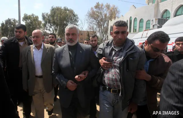 Palestinian prime minister in Gaza Strip, Ismail Haniya participates in the funneral of the three children who were killed in a domestic fire during their funeral during their funeral procession in Deir al-Balah in the c...