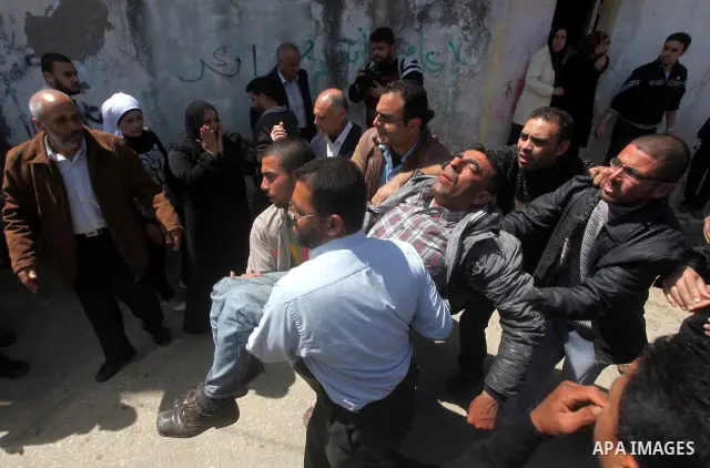 The father (C) of three Palestinian children who were killed the previous day in a domestic fire mourns during their funeral procession in Deir al-Balah in the central Gaza Strip on April 02, 2012. The three Palestinian...