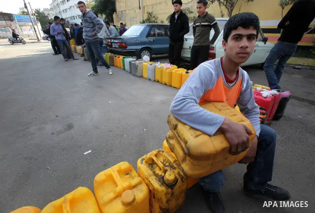 Palestinians wait in a queue to fill containers with fuel at a petrol station in Gaza City on April 2, 2012. The International Committee of the Red Cross (ICRC) began transferring emergency supplies of fuel to the Gaza S...