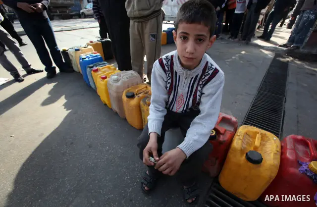 Palestinians wait in a queue to fill containers with fuel at a petrol station in Gaza City on April 2, 2012. The International Committee of the Red Cross (ICRC) began transferring emergency supplies of fuel to the Gaza S...