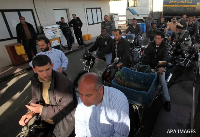 Palestinians wait in a queue to fill containers with fuel at a petrol station in Gaza City on April 2, 2012. The International Committee of the Red Cross (ICRC) began transferring emergency supplies of fuel to the Gaza S...
