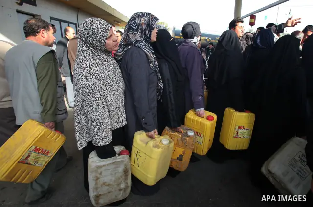 Palestinians wait in a queue to fill containers with fuel at a petrol station in Gaza City on April 2, 2012. The International Committee of the Red Cross (ICRC) began transferring emergency supplies of fuel to the Gaza S...