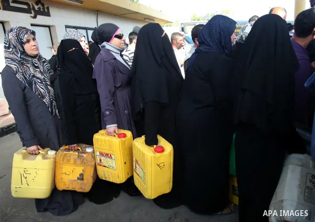 Palestinians wait in a queue to fill containers with fuel at a petrol station in Gaza City on April 2, 2012. The International Committee of the Red Cross (ICRC) began transferring emergency supplies of fuel to the Gaza S...