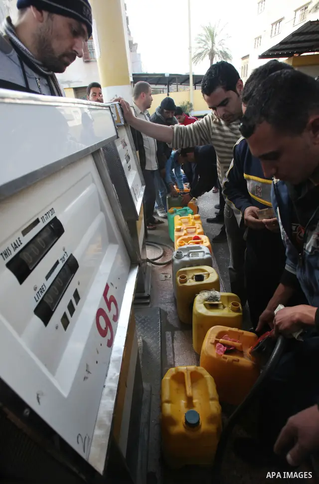Palestinians wait in a queue to fill containers with fuel at a petrol station in Gaza City on April 2, 2012. The International Committee of the Red Cross (ICRC) began transferring emergency supplies of fuel to the Gaza S...
