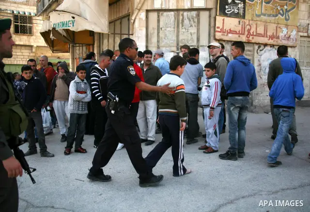 Israeli border police officers stand guard outside a building occupied by Jewish settlers in the West Bank city of Hebron April 3, 2012. Israeli Prime Minister Benjamin Netanyahu overruled the planned eviction on Tuesday...