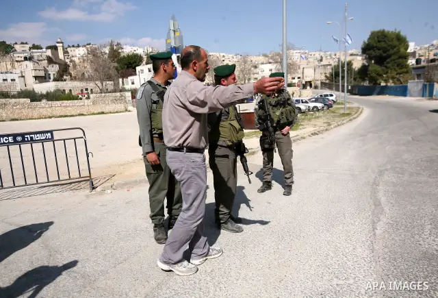 Israeli border police officers stand guard outside a building occupied by Jewish settlers in the West Bank city of Hebron April 3, 2012. Israeli Prime Minister Benjamin Netanyahu overruled the planned eviction on Tuesday...