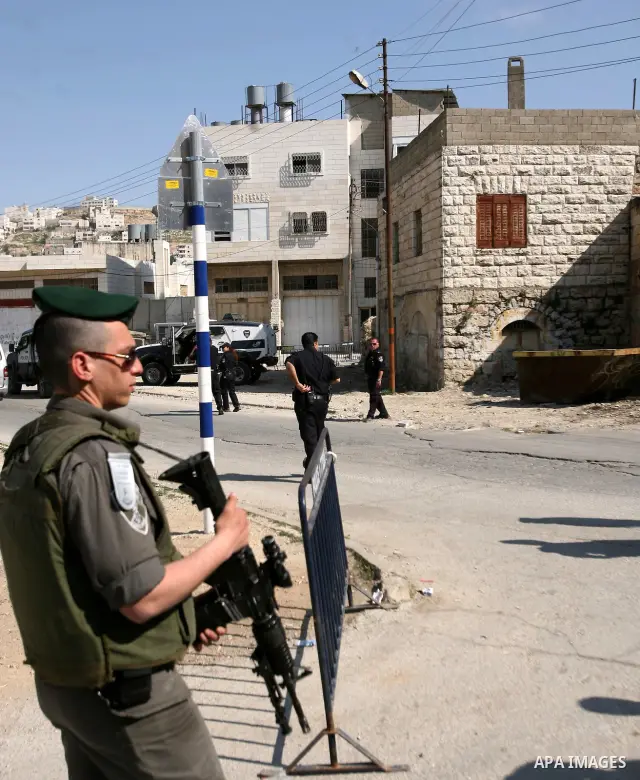 Israeli border police officers stand guard outside a building occupied by Jewish settlers in the West Bank city of Hebron April 3, 2012. Israeli Prime Minister Benjamin Netanyahu overruled the planned eviction on Tuesday...