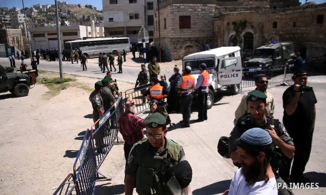 Jewish settlers stands near Israeli border policemen as they prevent her from reaching a building, occupied by Jewish settlers, in the West Bank city of Hebron April 4, 2012. Israeli police evicted Jewish settlers on Wed...