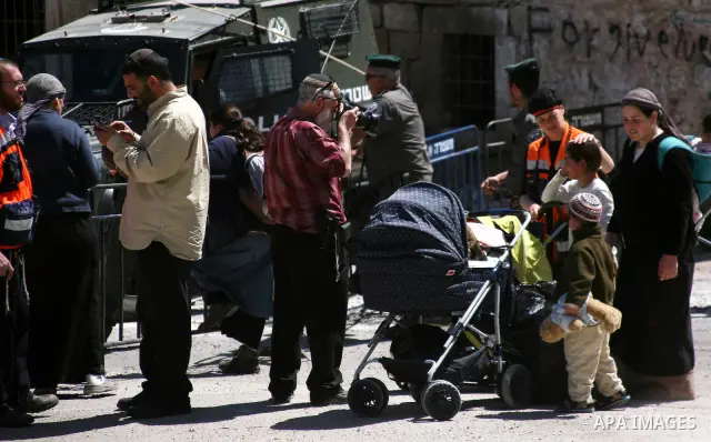 Jewish settlers stands near Israeli border policemen as they prevent her from reaching a building, occupied by Jewish settlers, in the West Bank city of Hebron April 4, 2012. Israeli police evicted Jewish settlers on Wed...