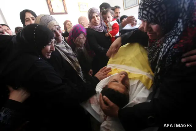 Palestinian women grieve as they watch the body of Palestinian youth Hashem Saed, 17-years-old, leave his home during his funeral in Gaza City on April 4, 2012, after he was shot overnight close along the border fence be...