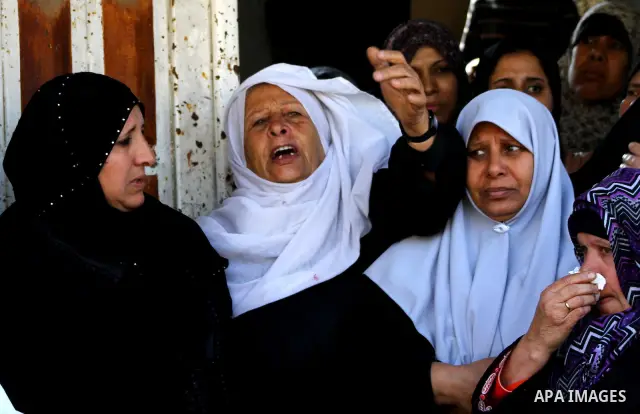 Palestinian women grieve as they watch the body of Palestinian youth Hashem Saed, 17-years-old, leave his home during his funeral in Gaza City on April 4, 2012, after he was shot overnight close along the border fence be...
