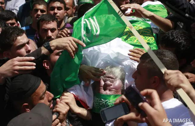Palestinian mourners gather around the body of Sheikh Hamed Al-Betawi member of the Legislative Council for Hamas during his funeral in the West Bank city of Thursday, April 5, 2012 . Photo by Wagdi Eshtayah