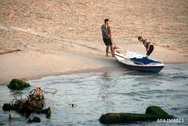 Palestinian fishermen pull their boat at the beach during sunset of Gaza city, 06 April 2012. Photo by Emad Nassar