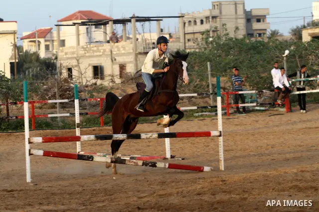 A Palestinian boy rides a horse during a championship at Gaza Horse Club in Gaza Strip, 06 April 2012. The clubs is home to some 54 horses and open for the training of male and female children aged between 12 to 23 years...