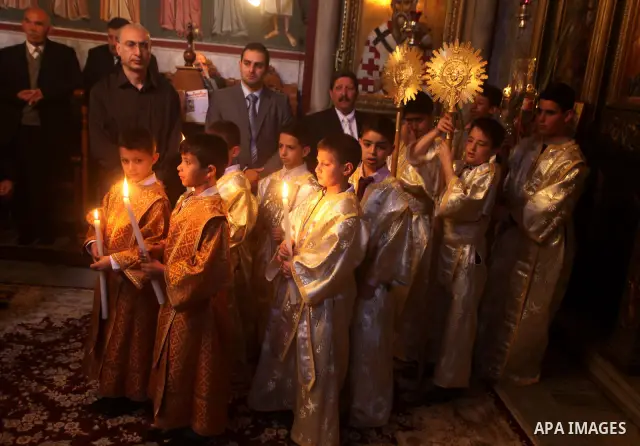 Palestinian Christian Catholics attend an Easter Vigil mass in Gaza City on April 8, 2012. Christians around the world mark the Holy Week of Easter to commemorate the crucifixion and resurrection of Jesus Christ. Photo b...