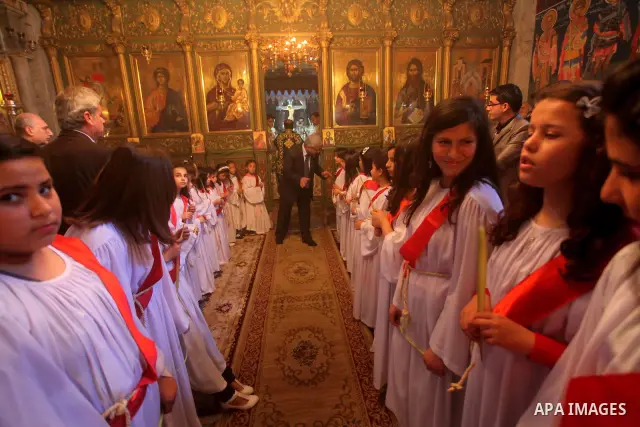 Palestinian Christian Catholics attend an Easter Vigil mass in Gaza City on April 8, 2012. Christians around the world mark the Holy Week of Easter to commemorate the crucifixion and resurrection of Jesus Christ. Photo b...
