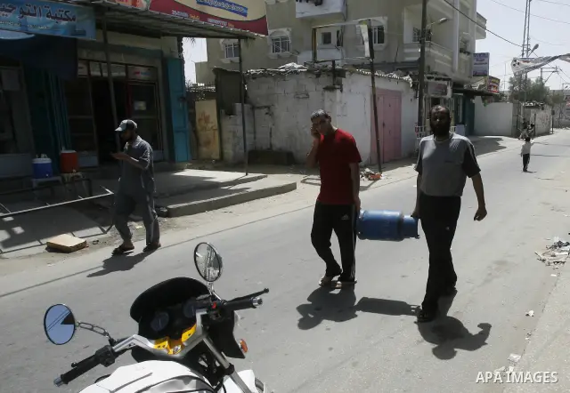 Palestinians carry gas cylinder is empty in the southern Gaza Strip refugee camp of Rafah, in Apr. 08, 2012. Photo by Eyad Al Baba