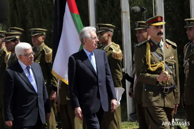 Palestinian President Mahmoud Abbas gestures meets with Italy's Prime Minister Mario Monti past an honour guard during a welcoming ceremony in the West Bank city of Ramallah April 8, 2012. Photo by Issam Rimawi
