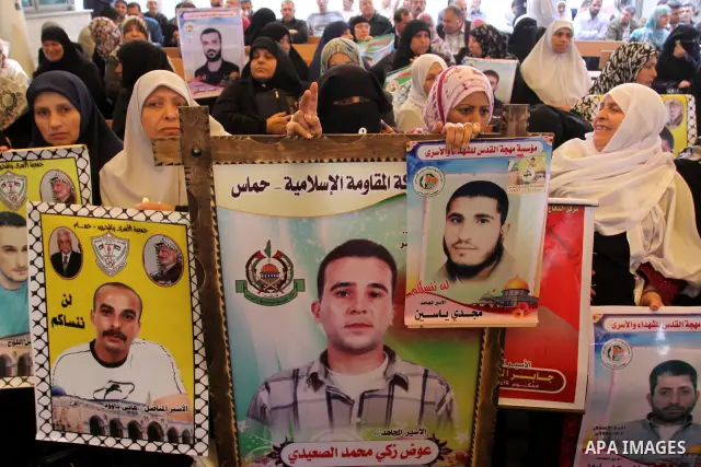 Palestinians hold pictures of their prisoned relatives in Israeli jails as they gather in a weekly activity calling for their liberty at the Red Cross headquarters in Gaza City on Apr. 09, 2012. Photo by Mohammed Asad