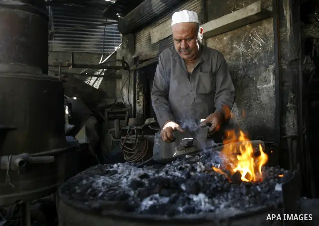 A Palestinian man works at a metal workshop in Rafah, southern Gaza Strip on April 10, 2012. Gaza has been in the grip of a severe power crisis for months now, with its sole electricity plant unable to function because o...