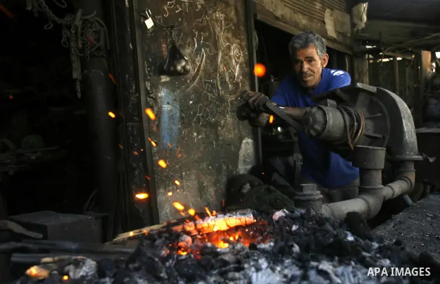 A Palestinian man works at a metal workshop in Rafah, southern Gaza Strip on April 10, 2012. Gaza has been in the grip of a severe power crisis for months now, with its sole electricity plant unable to function because o...