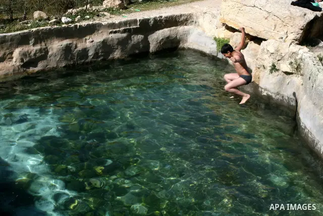 Palestinian boy jumps in the pool spring water "Jriot" near Ramallah in the West Bank, April 10, 2012. Photo by Issam Rimawi