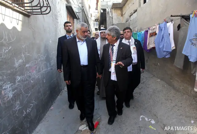 Palestinian Prime Minister in Gaza Strip, Ismail Haniya speaks with the Head of the Bahrani delegation during their tour to al-Shatea refugee camp in Gaza city on April 11,2012. The Bahrani delegation is in an official v...