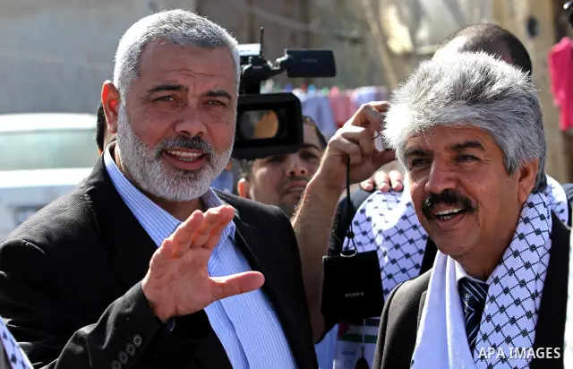 Palestinian Prime Minister in Gaza Strip, Ismail Haniya speaks with the Head of the Bahrani delegation during their tour to al-Shatea refugee camp in Gaza city on April 11,2012. The Bahrani delegation is in an official v...
