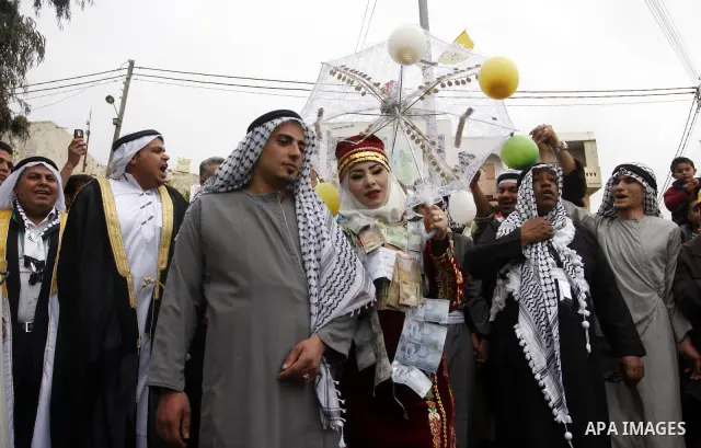 The Palestinian bride and groom Mhaha Salam (R) and Thayer Qasem (L), walk down the street on their wedding day on April 12, 2012 after they traveled from the refugee camp of al-Yarmuk in Syria, to get married in the Wes...