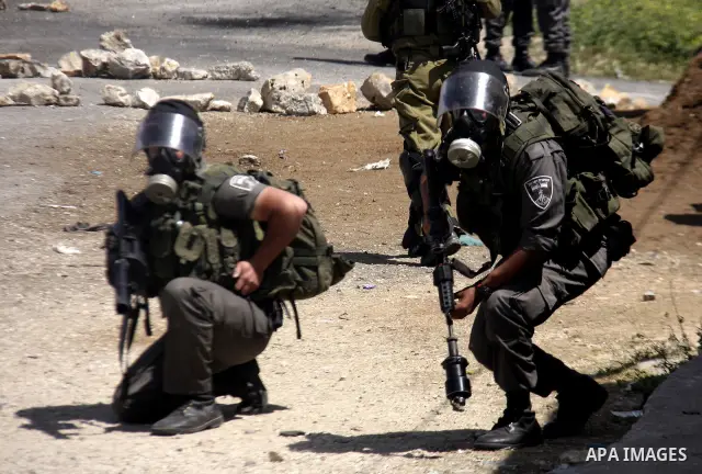 An Israeli soldier fires tear gas during clashes with Palestinians at a demonstration against the expropriation of Palestinian land by Israel in the village of Kfar Qaddum, near the West Bank city of Nablus, on April 13,...