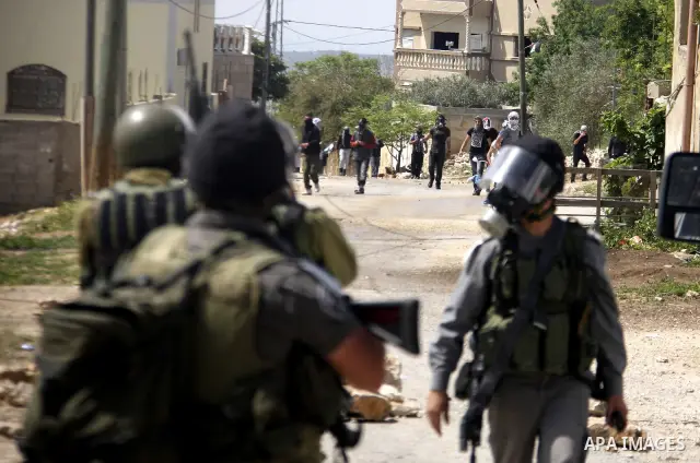Palestinian protesters throw stones at Israeli soldiers during clashes following a demonstration against the expropriation of Palestinian land by Israel in the village of Kfar Qaddum, near the West Bank city of Nablus, o...