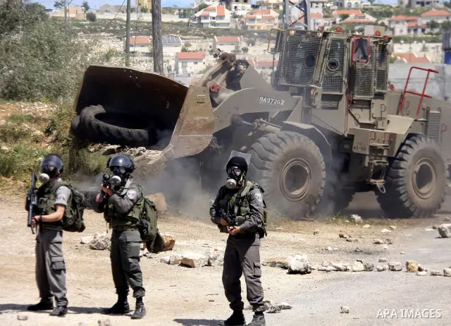 An Israeli soldier fires tear gas during clashes with Palestinians at a demonstration against the expropriation of Palestinian land by Israel in the village of Kfar Qaddum, near the West Bank city of Nablus, on April 13,...