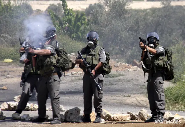 An Israeli soldier fires tear gas during clashes with Palestinians at a demonstration against the expropriation of Palestinian land by Israel in the village of Kfar Qaddum, near the West Bank city of Nablus, on April 13,...