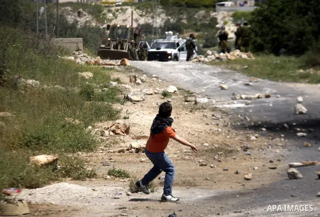 Palestinian protesters throw stones at Israeli soldiers during clashes following a demonstration against the expropriation of Palestinian land by Israel in the village of Kfar Qaddum, near the West Bank city of Nablus, o...