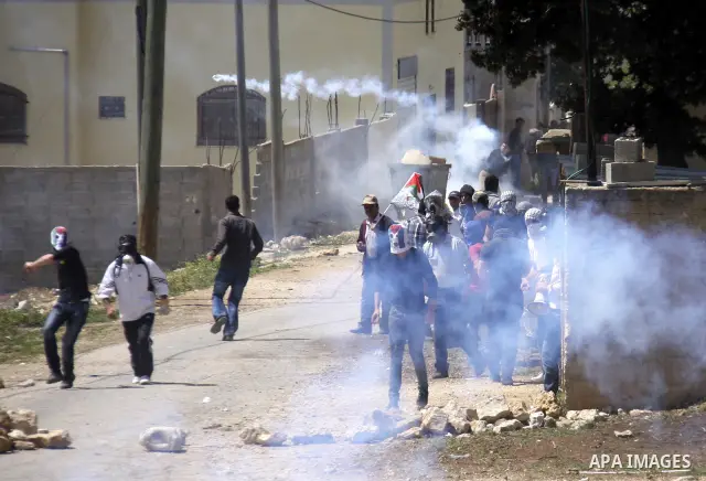 Palestinian protesters throw stones at Israeli soldiers during clashes following a demonstration against the expropriation of Palestinian land by Israel in the village of Kfar Qaddum, near the West Bank city of Nablus, o...