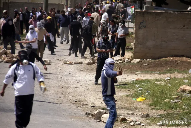 Palestinian protesters throw stones at Israeli soldiers during clashes following a demonstration against the expropriation of Palestinian land by Israel in the village of Kfar Qaddum, near the West Bank city of Nablus, o...