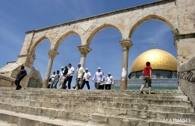 Palestinians walk in front of the dome of the rock and Al Aqsa mosque in the old city of Jerusalem on Apr. 13, 2012. Photo by Mahfouz Abu Turk