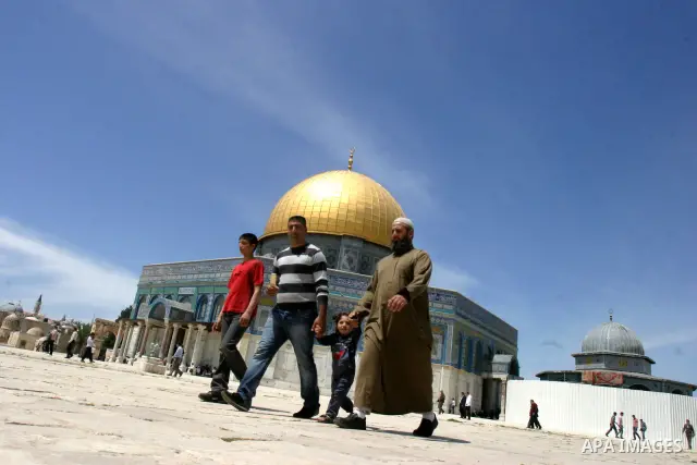 Palestinians walk in front of the dome of the rock and Al Aqsa mosque in the old city of Jerusalem on Apr. 13, 2012. Photo by Mahfouz Abu Turk