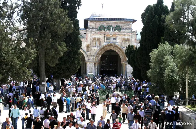 Palestinians walk in front of the dome of the rock and Al Aqsa mosque in the old city of Jerusalem on Apr. 13, 2012. Photo by Mahfouz Abu Turk