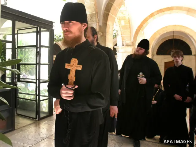 A Christian worshipper holds a cross in the Church of the Holy Sepulchre during the Eastern and Orthodox Church's Good Friday procession in the Old City of Jerusalem April 13, 2012. Photo by Mahfouz Abu Turk