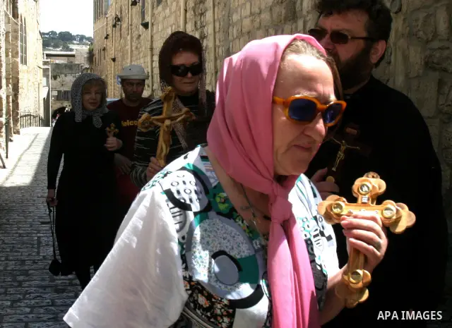 A Christian worshipper holds a cross in the Church of the Holy Sepulchre during the Eastern and Orthodox Church's Good Friday procession in the Old City of Jerusalem April 13, 2012. Photo by Mahfouz Abu Turk
