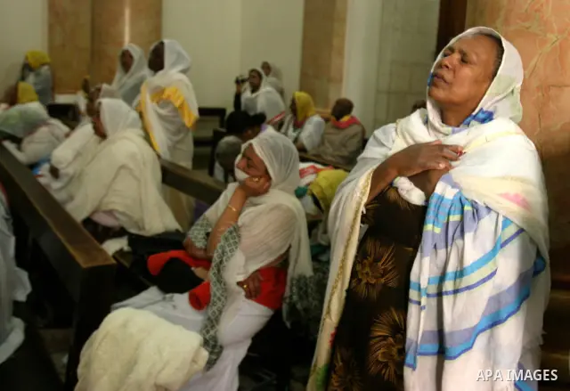 A Russian Orthodox woman weeps while looking skyward in the Church of the Holy Sepulchre on Good Friday in the Old City of Jerusalem. -- Eastern Orthodox Christians of many traditions converged on the Old City of Jerusal...