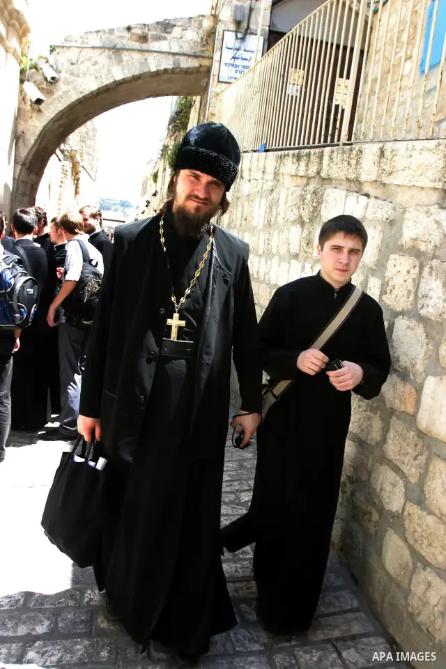 Russian Orthodox priests and pilgrims stop at the Fifth Station of the Cross along the Via Dolorosa on Good Friday in the Old City of Jerusalem. -- Eastern Orthodox Christians of many traditions converged on the Old City...