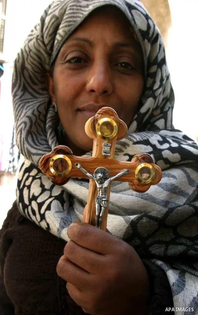 A Christian worshipper holds a cross in the Church of the Holy Sepulchre during the Eastern and Orthodox Church's Good Friday procession in the Old City of Jerusalem April 13, 2012. Photo by Mahfouz Abu Turk