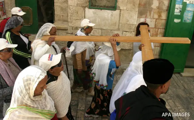 Orthodox Christian worshippers from Ethiopia carry a large cross during a Good Friday procession on the Via Dolorosa, retracing the route Jesus Christ walked to his crucifixion in Jerusalem, Israel, 13 April 2012. Thousa...