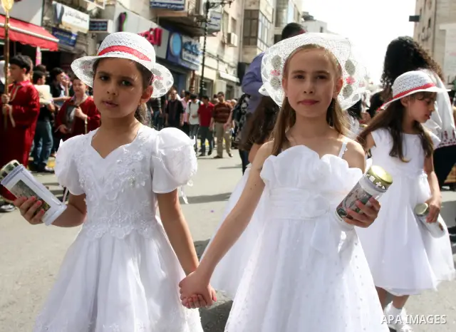 Palestinian Christian girls take part in the Holy Fire procession during Orthodox Easter holiday in the West Bank city of Ramallah, Saturday, April 14, 2012. Photo by Issam Rimawi