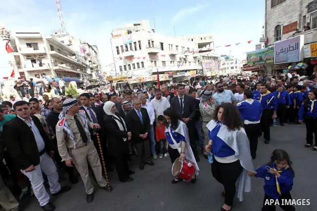 Palestinian Prime Minister Salam Fayyad takes part in the "Holy Fire" procession on the eve of Orthodox Easter in the West Bank city of Ramallah on April 14, 2012. The date of Orthodox Easter is calculated differently th...